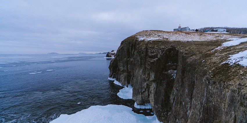 A rugged brown cliff mountain is a popular destination near Quttinirpaaq National Park.