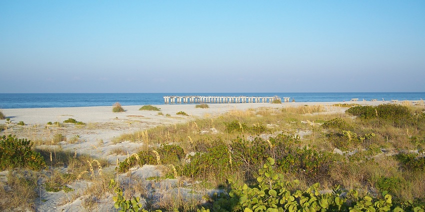 An image of Gasparilla Island State Park with clear waters and a soft, sandy shoreline