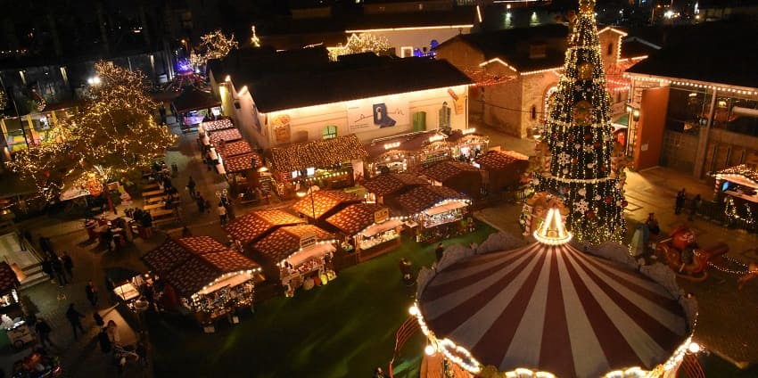 Christmas factory with a carousel, a tall decorated Christmas tree and small shops