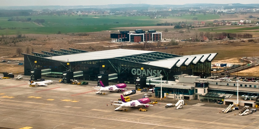 Gdańsk Lech Wałęsa Airport with multiple aeroplanes parked and a terminal building
