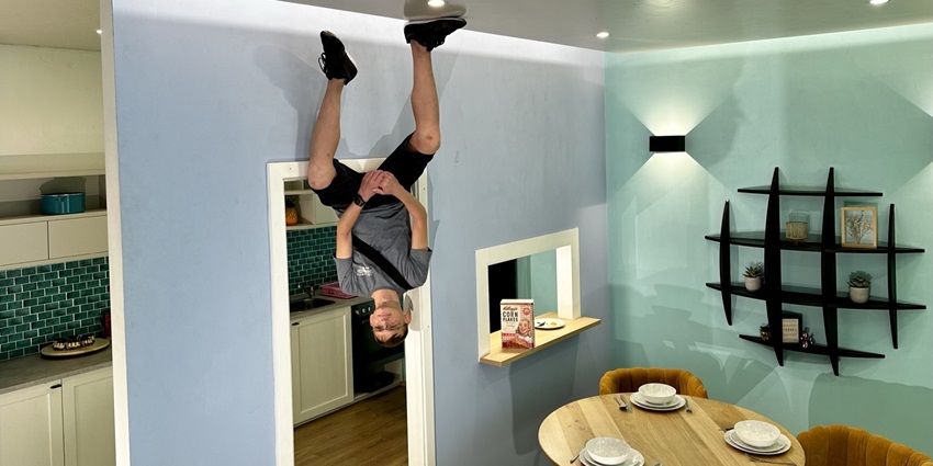 A picture of a tourist enjoying at the Upside Down Museum in Amsterdam, creating illusions