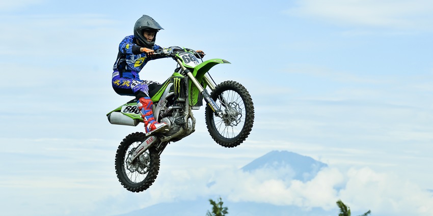A picture of a professional biker performing stunts on a dirt bike at the Lake Tahoe biking arena