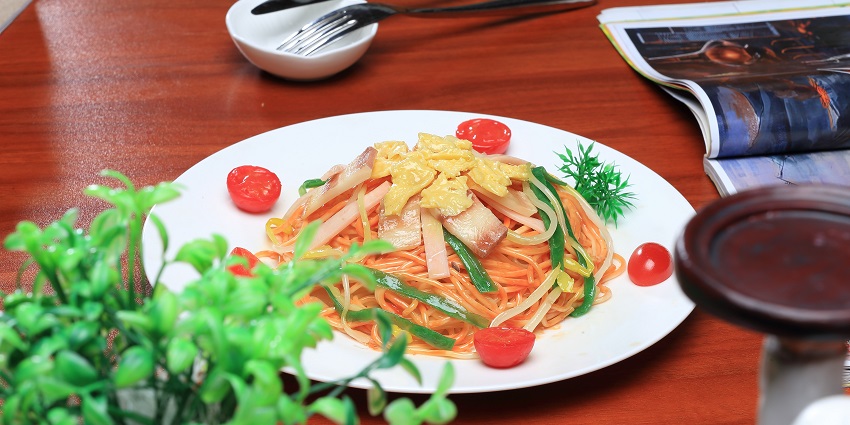 Image of an appetising food served on a white plate with decorated wooden table a