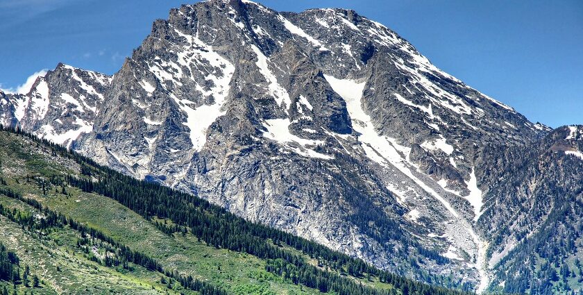 An image of Teton Range with snow-capped peaks and Willow Flats' green meadows.