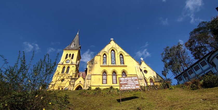 An image of the Darjeeling with equally stunning multi-hued buildings and mountains behind them.