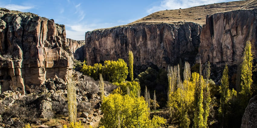 Embark on a scenic hike surrounded by stunning cliffs in the Ihlara Valley, Turkey.