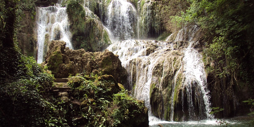 Krushuna waterfalls with big stones, surrounded by greenery forming a river