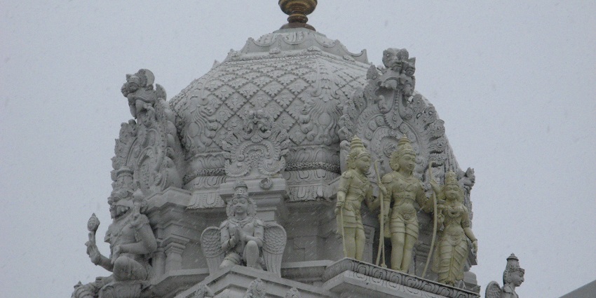 A view of a large Hindu temple with a tall spire, considered the best temple in Illinois.