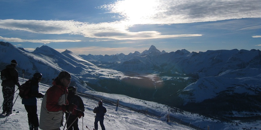 A group of tourists enjoy skiing at a ski trail in the Sunshine Village, Banff, Alberta.