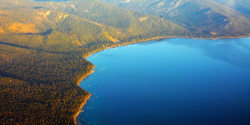 A mesmerising aerial view of the Lake Tahoe surrounded by greenery in California, USA.