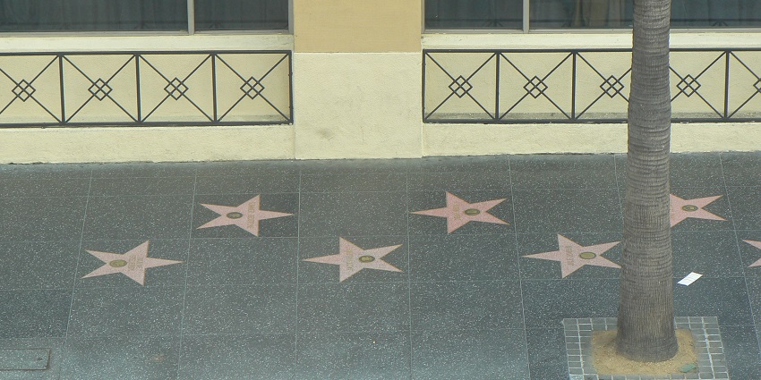 The Walk of Fame with stars, set into the grey tiled sidewalk along Hollywood Boulevard