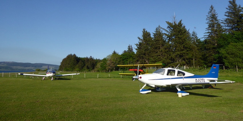 View of Stewart Island’s airstrip surrounded by lush greenery under clear blue sky