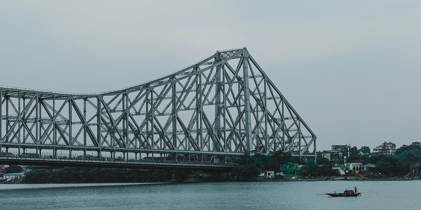 An image of scenic Kolkata view from the iconic Howrah Bridge spanning over Hooghly River.