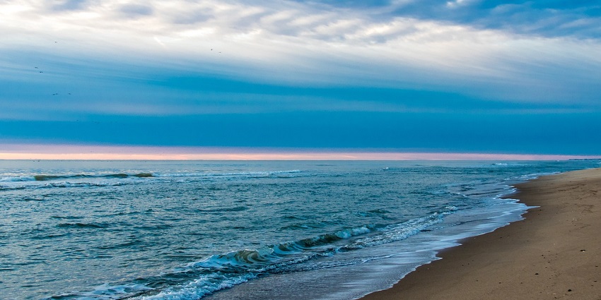 An image of a beach which resembles Huntington Beach, a famous beach in Orange County.