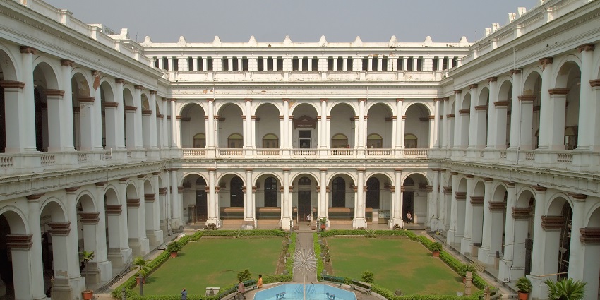 A beautiful view of the courtyard of the Indian Museum featuring gardens and a fountain.