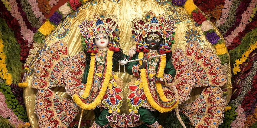 An image of Lord Radha Krishna in a beautiful green dress in an ISKCON temple