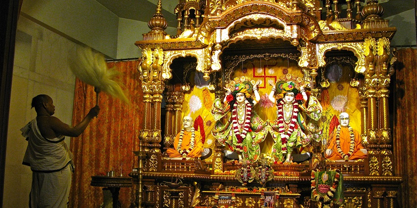 A guru offering rituals in the inner chamber of the Iskcon temple.