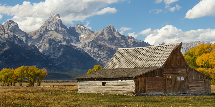 A breathtaking view of a hut in Jackson Hole with snow-capped mountains in the background.