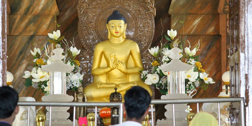 An image of a Jain Centre BC , which is in between of mountains with some tourists.
