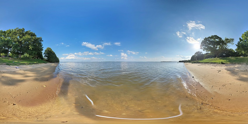 Picture of a scenic beach in Jamestown, Virginia with clear water and greenery around.