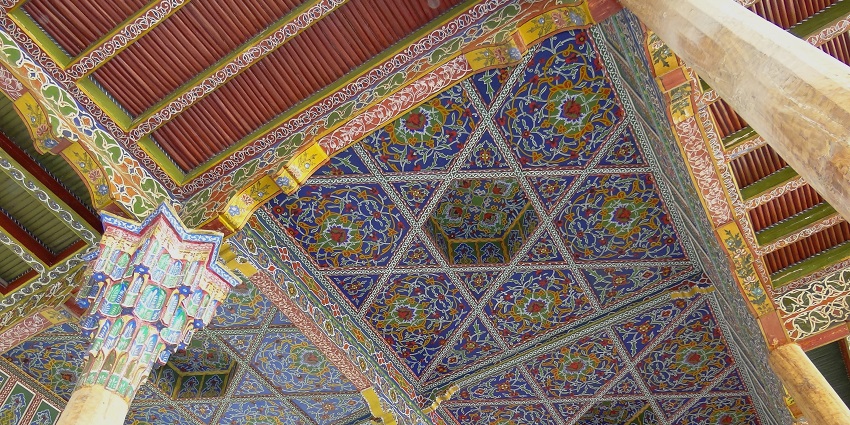 A high-angle view of a tall building with intricate architectural details and geometric designs.
