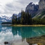 A scenic view of the Athabasca River flowing through Jasper National Park with mountains