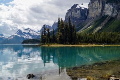 A scenic view of the Athabasca River flowing through Jasper National Park with mountains