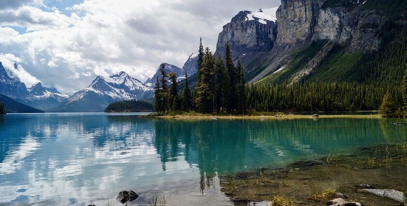 A scenic view of the Athabasca River flowing through Jasper National Park with mountains