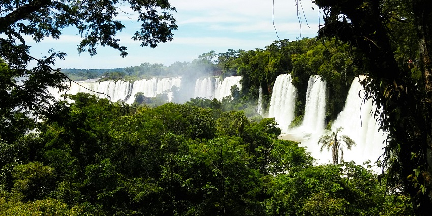 A beautiful waterfall surrounded by dense green trees, creating a peaceful and natural setting.