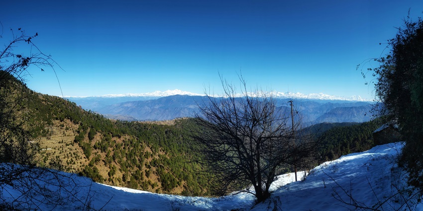 New Tehri reservoir nestled between lush green mountains under cloudy skies in Uttarakhand.