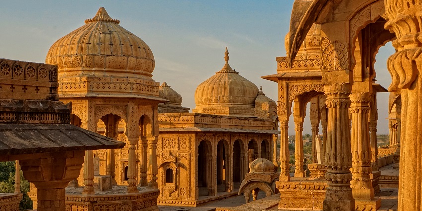 An image of a pleasant view of a temple building with a dome under the golden light of the evening sky