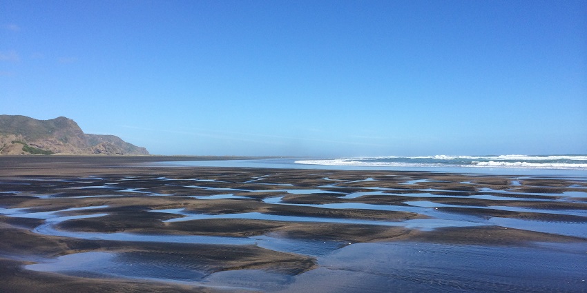 Secluded and scenic, with rugged cliffs, surrounded by black sand - Karekare Beach.