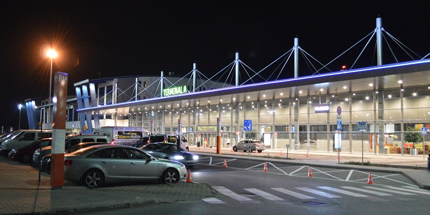 Entrance gate of Katowice Airport at night with a terminal, signage and vibrant lighting
