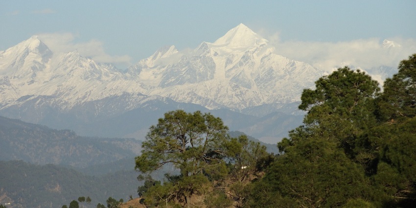 A beautiful view of Kausani with snow-capped peaks and lush valleys.