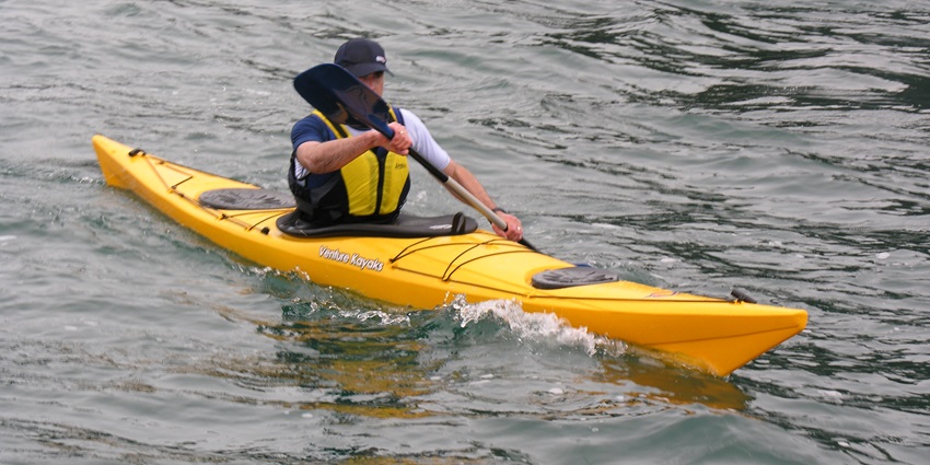 A picture of a man kayaking through the Lake Tahoe amidst the clear blue waters