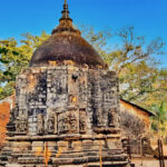 Image of Koteshwar temple surrounded by lush greenery during day time