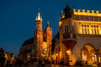 St Mary’s Basilica at night with well-lit buildings and people exploring around