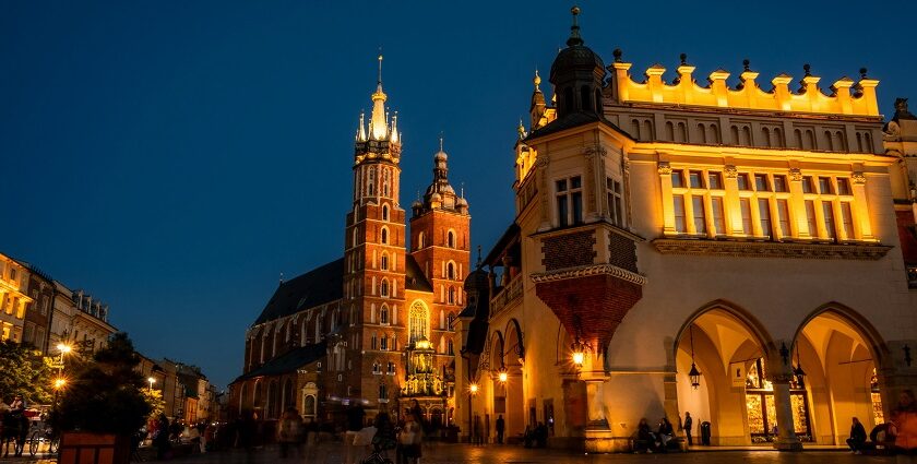 St Mary’s Basilica at night with well-lit buildings and people exploring around