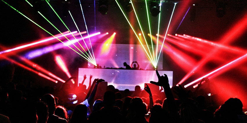A DJ playing music standing at Kulturhaus where you can ejoy the vibrant Romania nightlife.