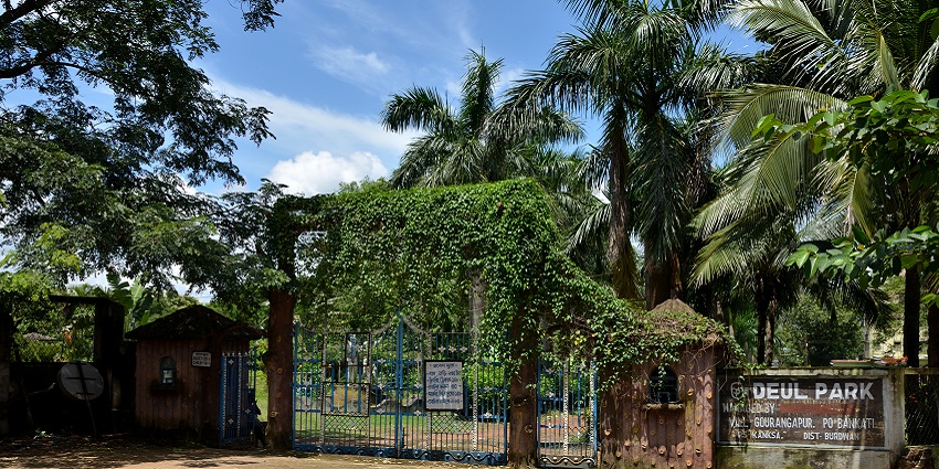 An image of Kumar Mangalam Park including a toy rail track and a pond and trees.