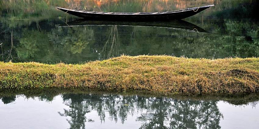 Scenic Kusumgram Lake surrounded by greenery, perfect for picnics and boating