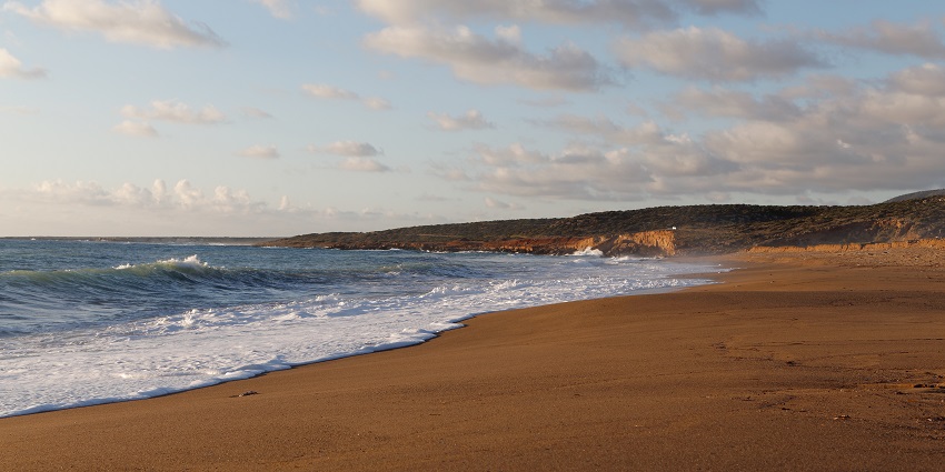Popular resort beach with golden sand, clear waters, and amenities.