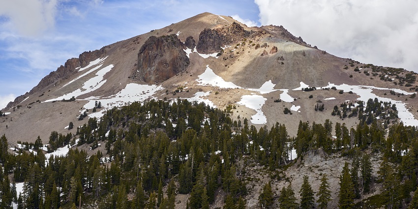 Lassen Peak in Lassen Volcanic National Park as seen from the shore of Lake Helen.