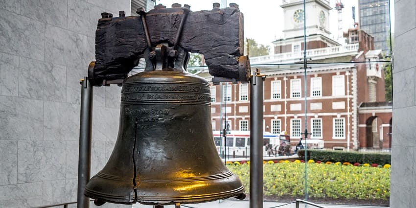 A view of big-sized liberty bell on display in front of the liberty bell centre and a small lawn.