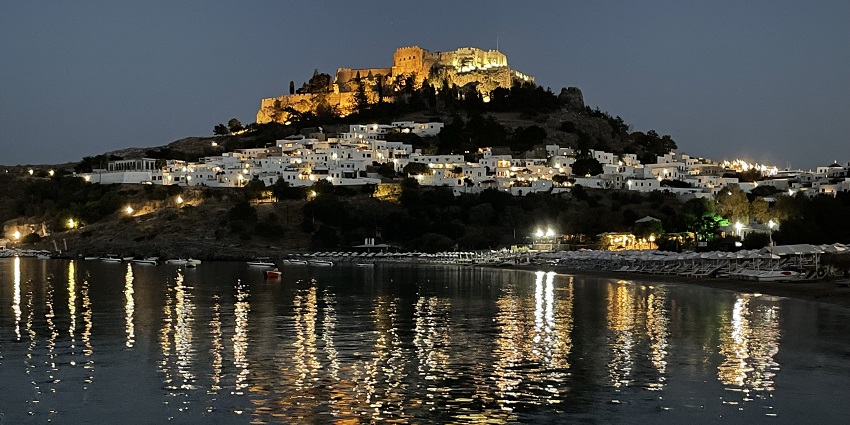 Lindos Bay illuminated Rhodes Island at night and the hill reflecting on the waters