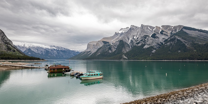 Lake Minnewanka in Canada, with clear blue water and surrounding mountains.