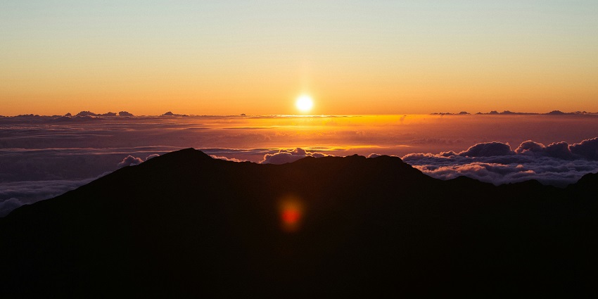 Scenic view of Haleakala National Park showcasing its volcanic terrain and cloud-filled sky.