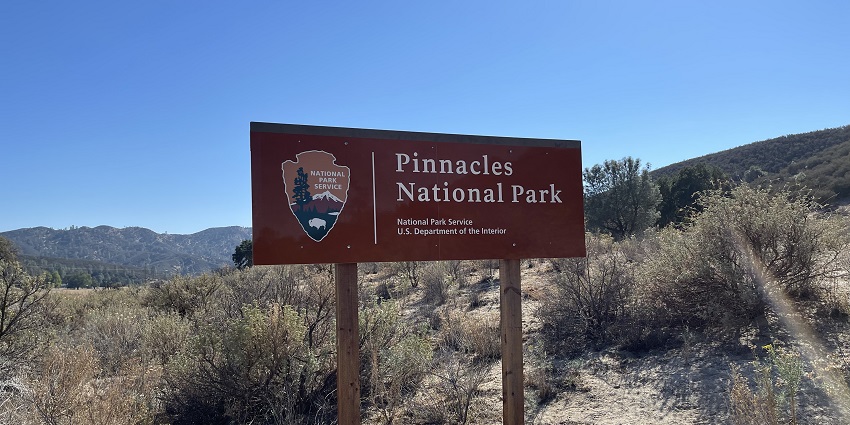 An image of the sign of Pinnacles National Park with nature and a diverse environment.