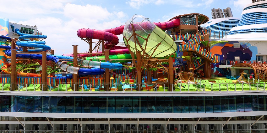 An image of a thrilling water park with slides, and lounging areas built on a cruise ship