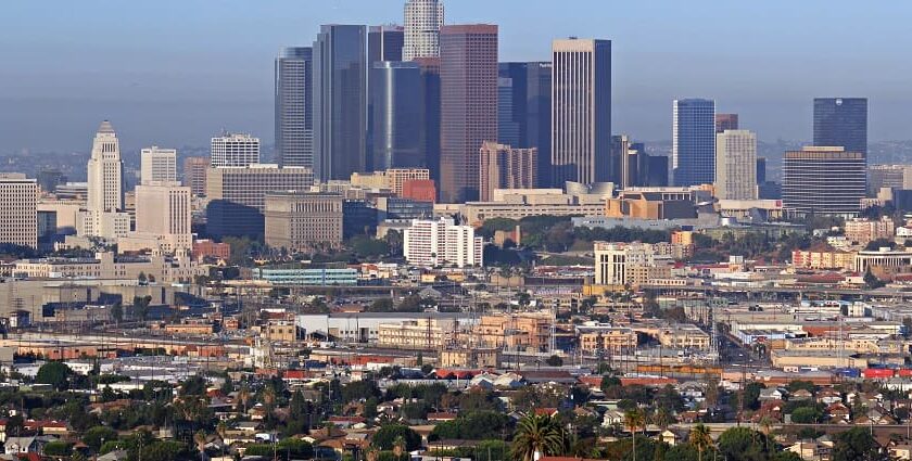 A view of the Downtown Los Angeles skyline, featuring tall skyscrapers, lights, and a clear sky.